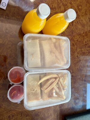 朝食BOXのサンドイッチ、ポテト、フルーツ、オレンジジュース